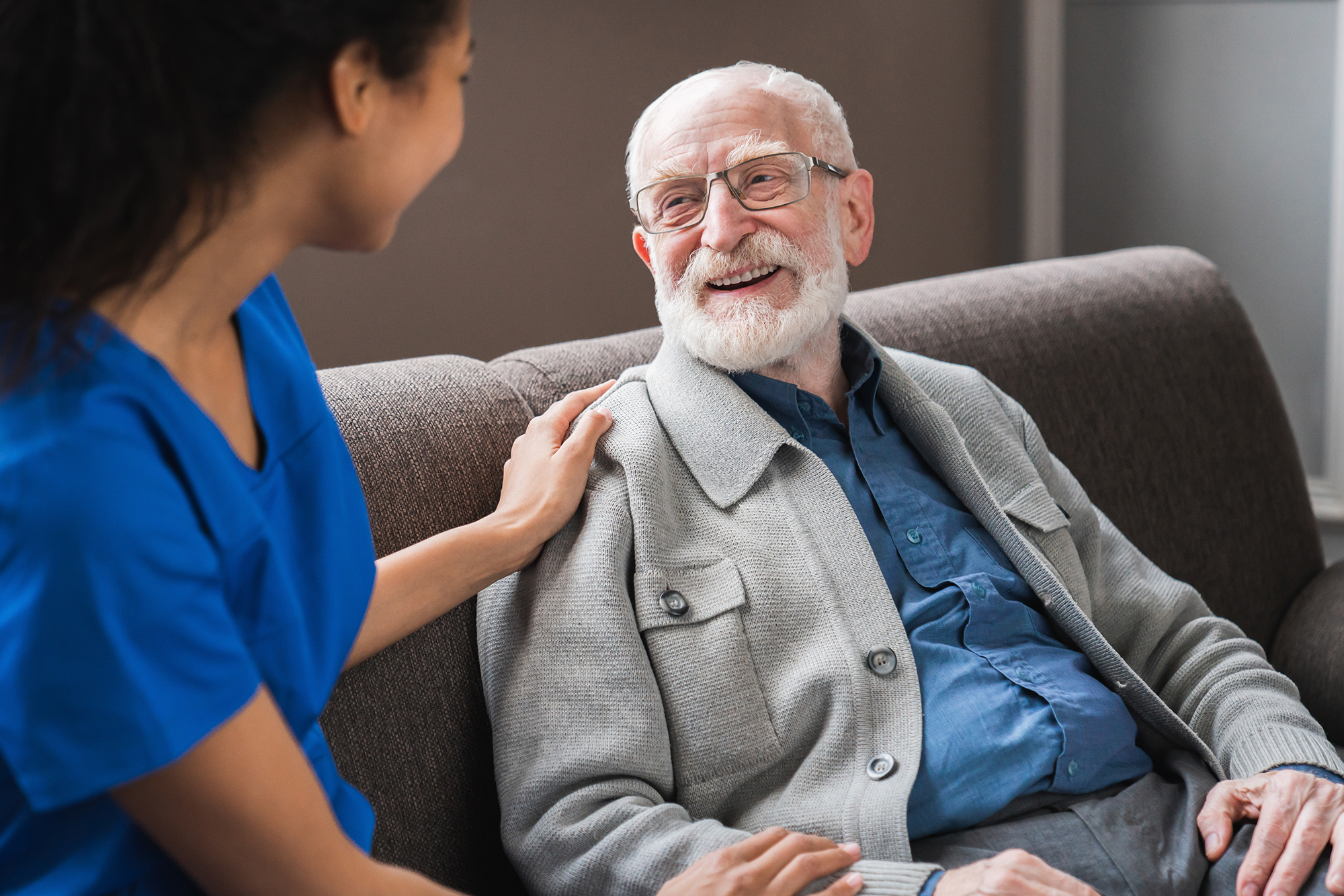 African Female Caregiver Talking To Happy Senior Man